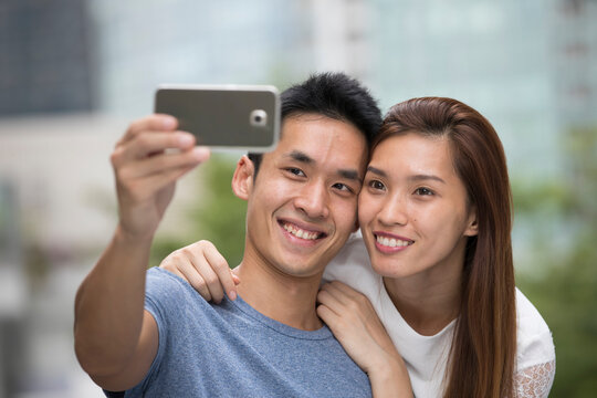Happy Asian couple taking a 'Selie' self portrait.