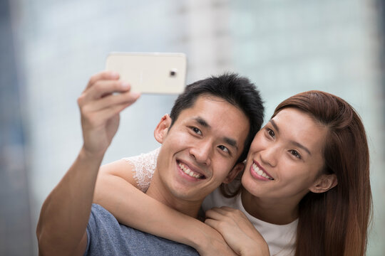 Happy Asian couple taking a 'Selie' self portrait.