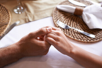 Holding hands, couple and table for support with love in restaurant for care, affection and leisure...