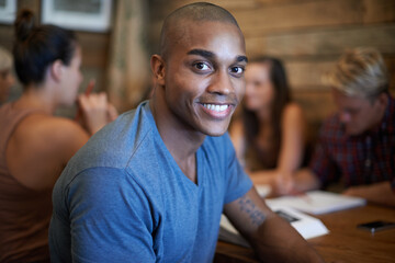 Portrait, smile and student man with group, African male scholar and happy for university knowledge. Relax and break from book study, learning from research at table for educational development