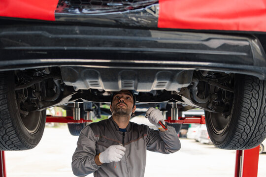 Professional automobile maintenance checking car damage broken part condition with clipboard. Diagnostic and repairing vehicles at garage automotive.