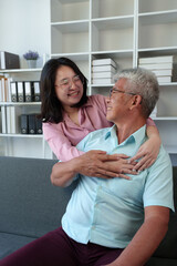 Surprised Asian woman hugs elderly father Teasing in various verses Reading in the living room...