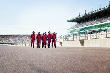 Racing team poised on the track for action. Pit crew in action during a tire change at a race track.  