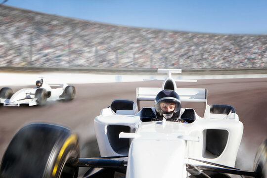 Racecar driver in focus speeding on a track with competitors in pursuit 