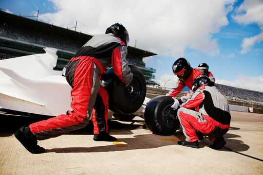 Pit crew in synchronized action during a highspeed race change 
