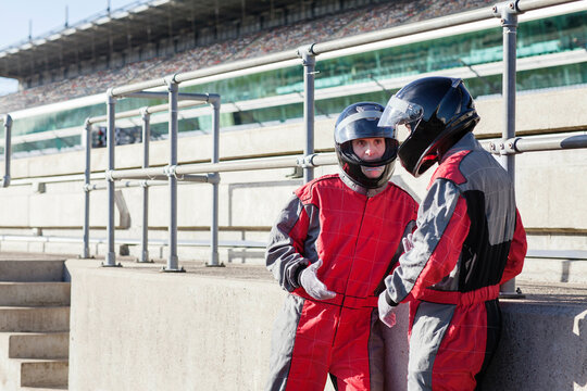 Two racers in conversation at the racetrack. 