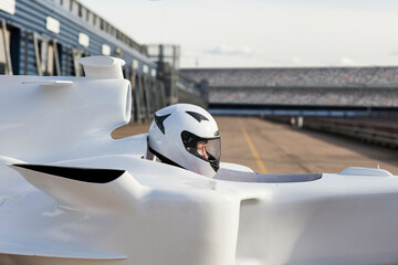 Ready to race A driver in a sleek white racing car at the starting line. 