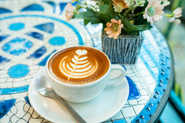 Hot coffee latte with latte art milk foam in cup mug on marble floor desk As breakfast In a coffee...
