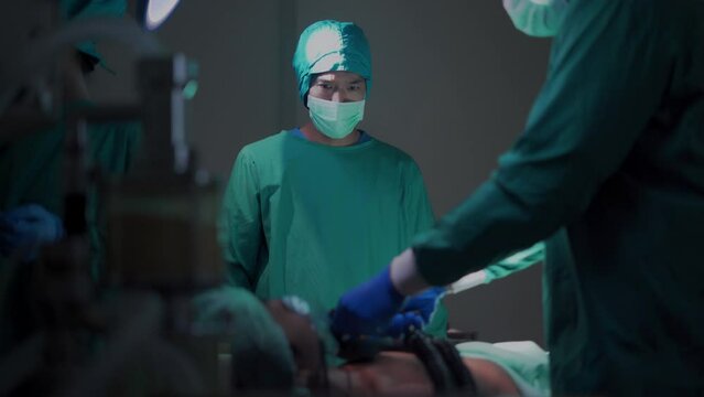 A professional medical team in the operating room helps the patient, performs CPR and uses an electrical defibrillator to shock the heart.