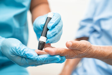 Doctor check diabetes from finger blood sugar level with finger lancet.