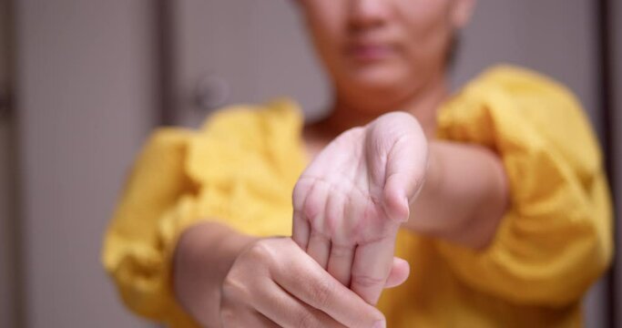 Massaging and stretching her hands and fingers moving it downwards and upwards to relive the pain and inflammation.
