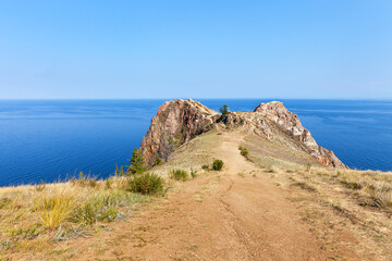 Baikal Lake in summer. View of famous Cape Shunte Left or as it is also called Cape of Love - natural landmark of Olkhon Island from dirt path. Beautiful summer landscape. Natural background