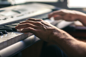 man hands playing the piano close-up. musical keyboard
