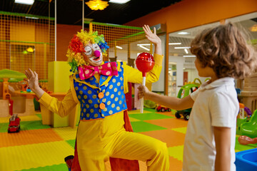 Birthday celebration concept, little boy giving huge lollypop for clown