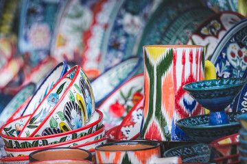 Multi-colored ceramic products with oriental ornaments at the Siab Bazaar in the ancient city of Samarkand in Uzbekistan, Siyob bozor - obrazy, fototapety, plakaty