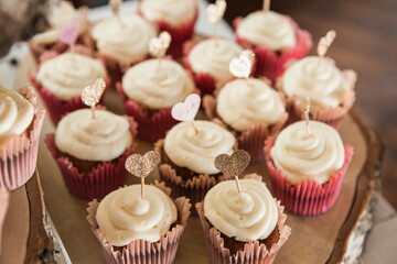 wedding cupcakes decorated with heart-shaped candles on top, wedding candy bar