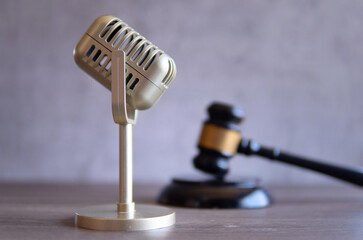 Closeup image of microphone and judge gavel. Entertainment law concept.