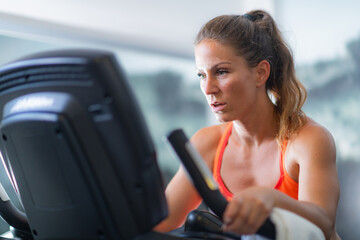 Active young women engaged in cardiovascular exercise on a treadmill, promoting fitness and...