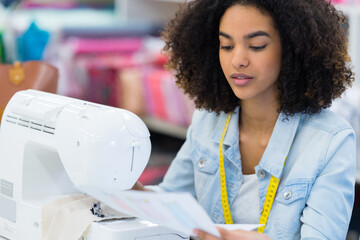 young industrial seamstress studying the design drawn in the blueprint