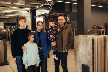 a young family chooses tiles for their home in a hardware store