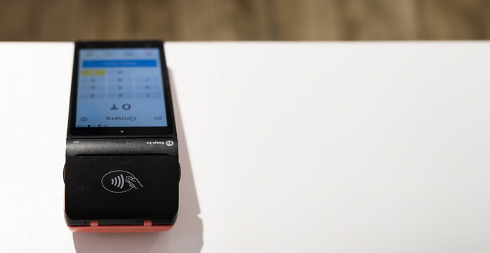 Uralsk, Kazakhstan - 27.02.24: Pos payment terminal device for reading banking cards in the cafe. Kaspi Bank