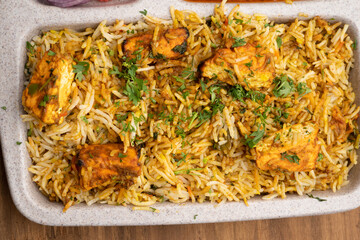 Paneer tikka biryani with onion raitha, vegetable biryani, hyderabadi biryani, south indian biryani served in plate