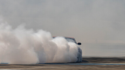Blurred car drifting diffusion race drift car with lots of smoke from burning tires on speed track, Professional driver drifting car with lots of white smoke . © Kalyakan