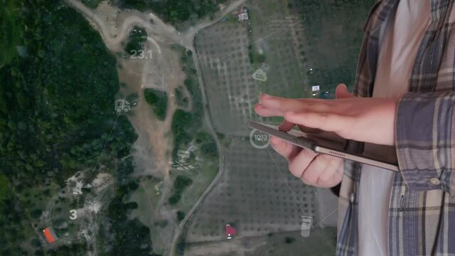 POV of a farmer using digital tablet in the vegetable farm, organic smart farm control by science technology and visual graphic display.