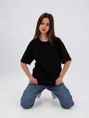 mockup of a black loose-fitting t-shirt on a young beautiful girl