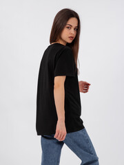 mockup of a black loose-fitting t-shirt on a young beautiful girl