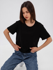 mockup of a black loose-fitting t-shirt on a young beautiful girl