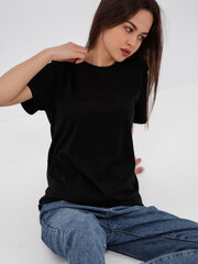 mockup of a black loose-fitting t-shirt on a young beautiful girl