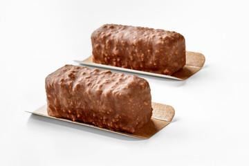 Two nuts and chocolate covered ice cream bars on white