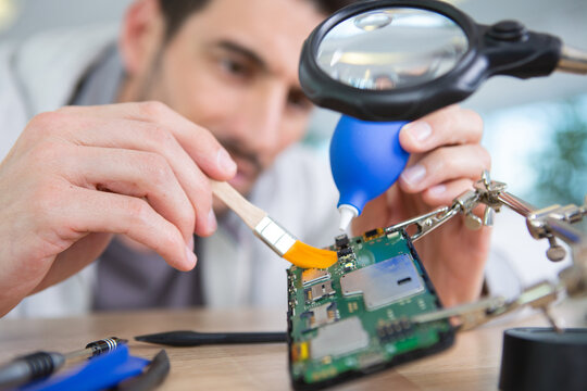 male tech or engineer repairs electronic equipment