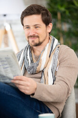 handsome young man reading newspaper