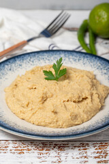 Roasted eggplant salad. Traditional Asian flavors. Appetizer made with roasted eggplant and various ingredients. Roasted eggplant appetizer on a white wood background. Close up