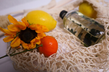 Eco shopping bag in which there is a cosmetic bottle, fruits and a sunflower flower