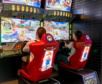 Queenstown, New Zealand- 29 December, 2023: Two players are deep in competition at a racing arcade game in Kingpin Queenstown, surrounded by lively game graphics.