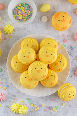 Cute Easter chick macarons. French macarons with vanilla cream and lemon curd on a concrete background. Funny food idea. Copy space. © irina2511