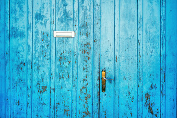 Old blue worn wooden door with letter box