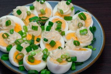 Połówki jajek ugotowanych na twardo na talerzu z majonezem z bliska - obrazy, fototapety, plakaty