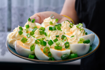 Gotowane Jajka przekrojone na pół udekorowane majonezem na talerzu  - obrazy, fototapety, plakaty