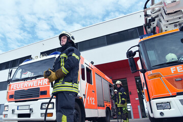 Group of firefighters at the emergency vehicle in the fire station