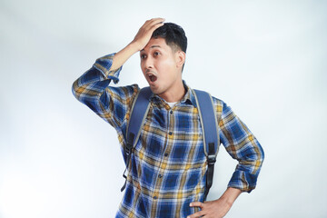 surprised young Asian student man in casual clothes with backpack Put hands on his head with an open mouth isolated on white background. High school university college concept