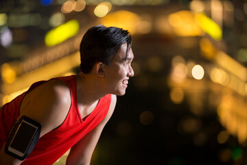 Sporty Asian man outdoors in urban city at night