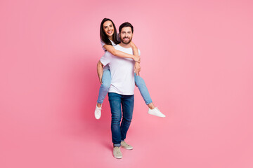 Full size photo of attractive young couple piggyback dating have fun wear trendy white outfit isolated on pink color background