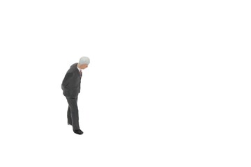 miniature figurine of a senior businessman standing on a white background