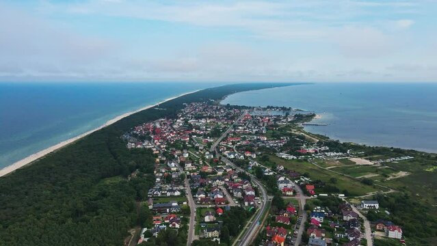 Birds eye view of sea landscape with sandy beach and Jastarnia city on Hel peninsula. Baltic Sea coast in Poland. Resort town in the summer season