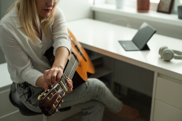  woman blogger live steam playing guitar on social media.