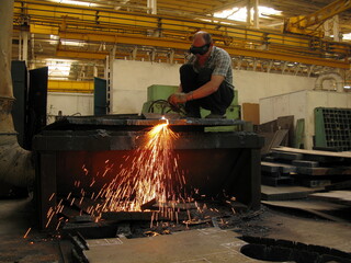 Russia Samara. July 2, 2009: a worker in a workshop cuts metal blanks with a gas torch, Soviet era.